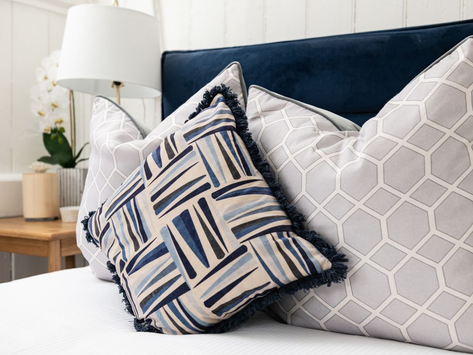 A collection of pillows on a bed at Stable in Blandford Forum