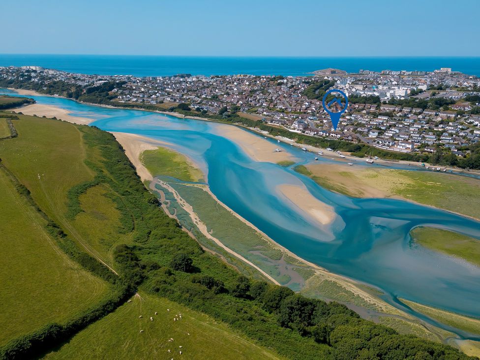 An aerial view of a river and houses near the ocean at Newquay Tamarisk Lodge on the Gannel, Newquay