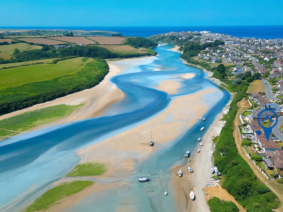 A river with boats and houses along the bank at Newquay Tamarisk Lodge on the Gannel in Newquay