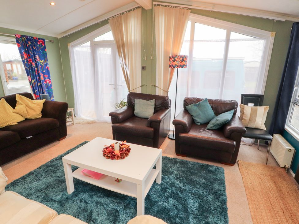 A living room with sofas and a coffee table at Rosie's Zen Den near High Hesket Armathwaite