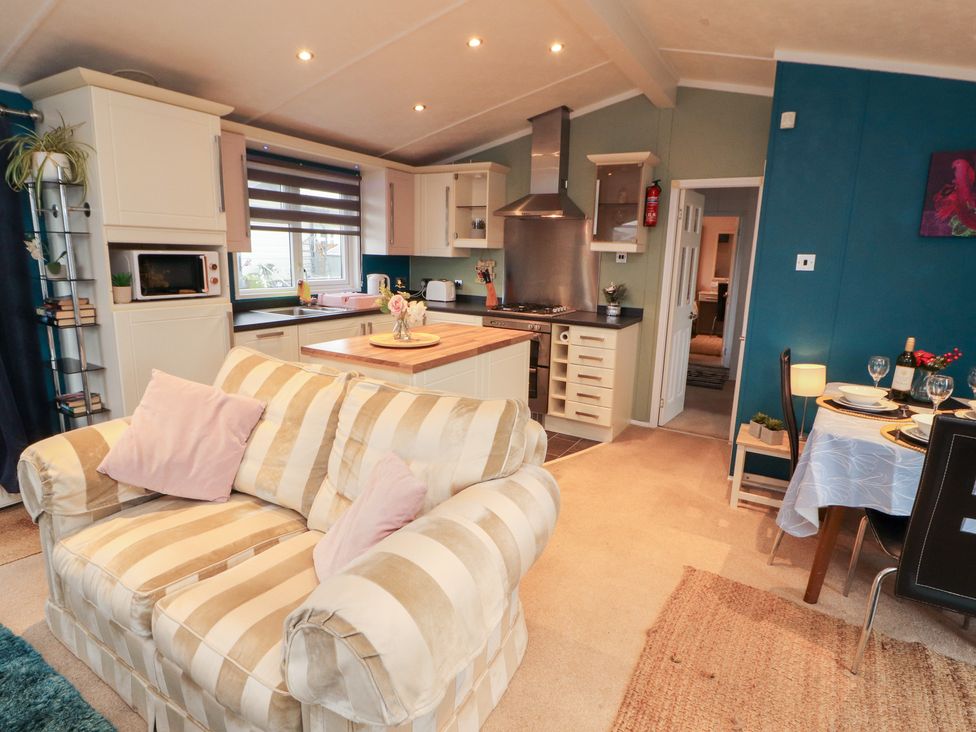 A kitchen with a sofa and dining area at Rosie's Zen Den in High Hesket near Armathwaite