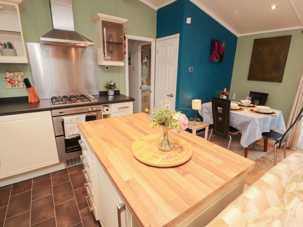 A kitchen with a gas stove and dining table at Rosie's Zen Den in High Hesket near Armathwaite