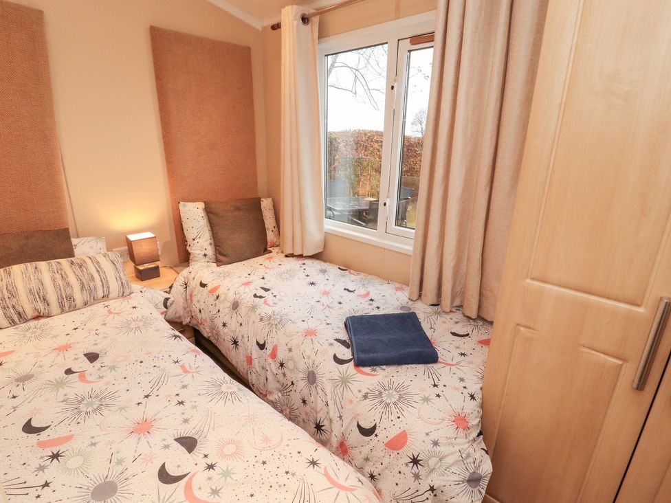 A bedroom with two beds and a window at Rosie's Zen Den in High Hesket near Armathwaite