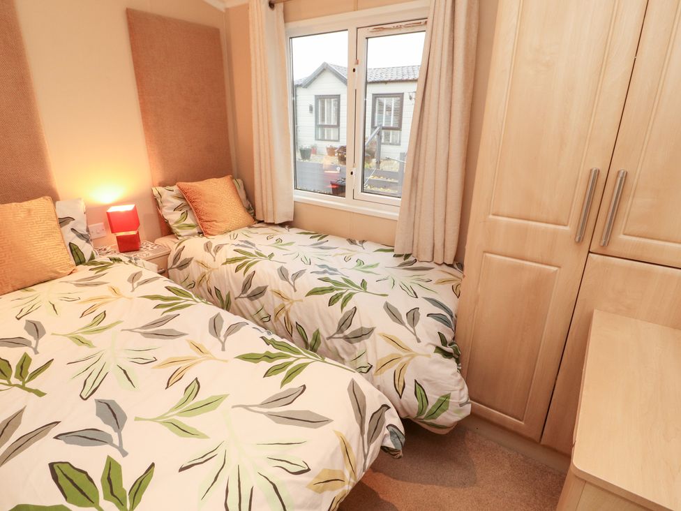 A bedroom with two beds and a window at Rosie's Zen Den in High Hesket near Armathwaite