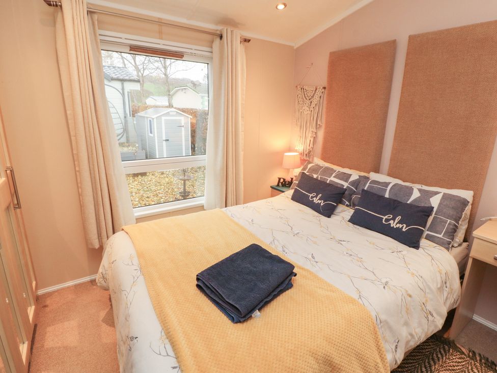 A bedroom with a bed and window view at Rosie's Zen Den near High Hesket