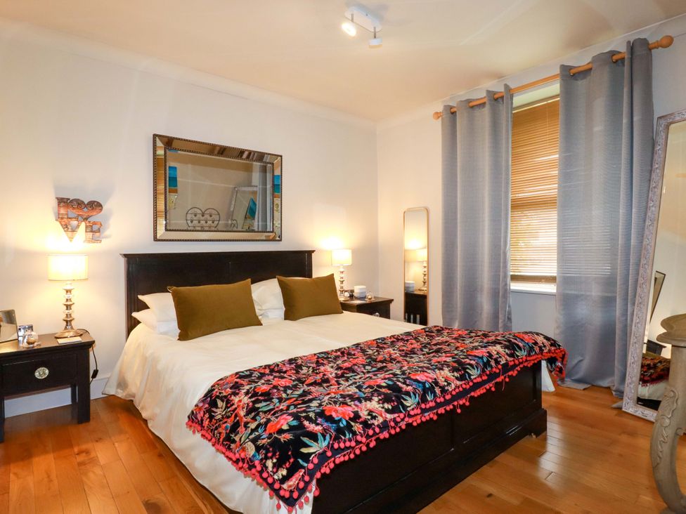 A bedroom with a bed and nightstands at Sea View in St Austell