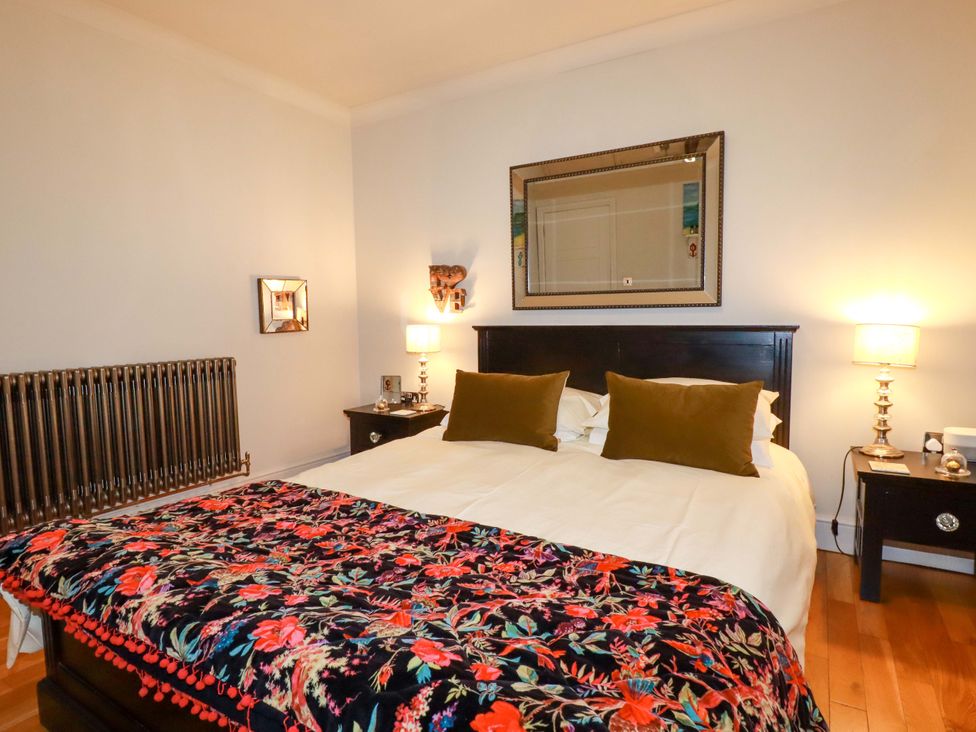 A bedroom with a bed and bedside tables at Sea View, St Austell