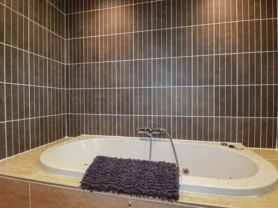 A bathtub with a rug in a bathroom at Sea View in St Austell