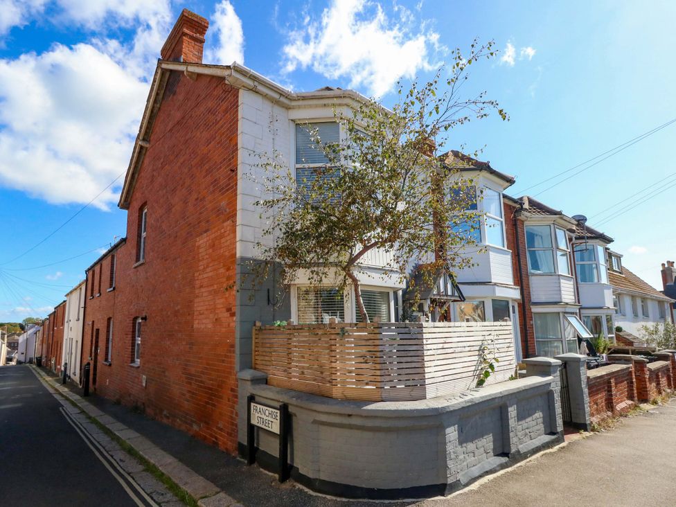 A house with a tree and a fence on Franchose Street at The Old Post Office in Weymouth