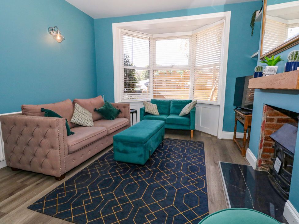 A living room with a sofa and footstool at The Old Post Office in Weymouth