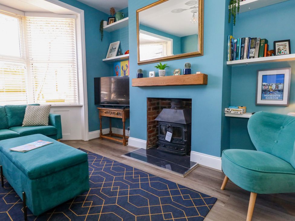 A living room with a television and fireplace at The Old Post Office in Weymouth