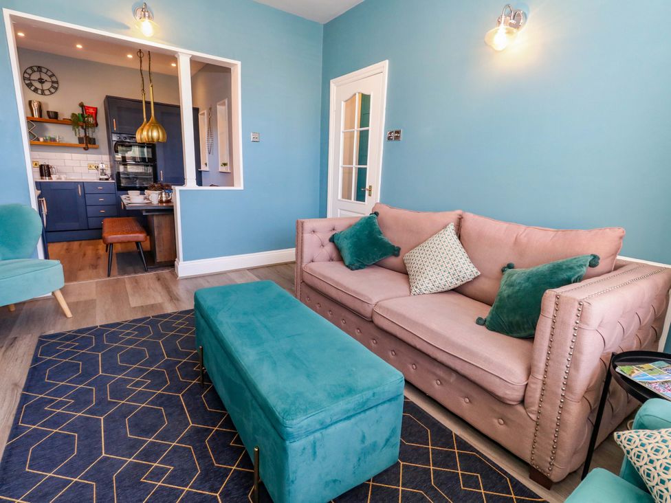 A living room with a sofa and ottoman at The Old Post Office in Weymouth