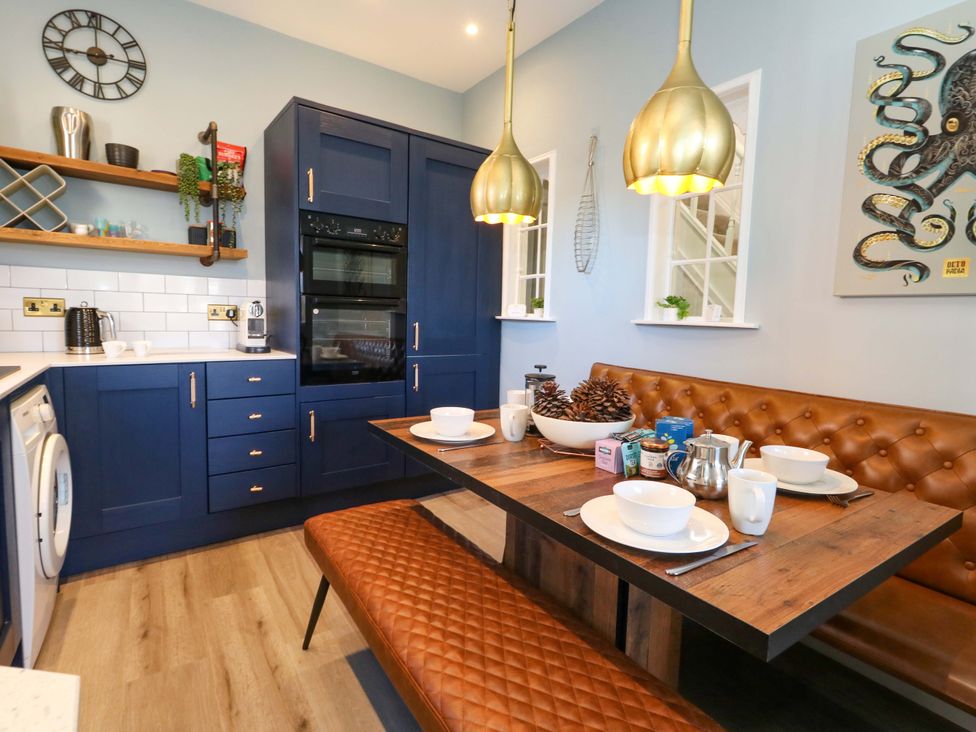 A kitchen with a table and chairs at The Old Post Office in Weymouth