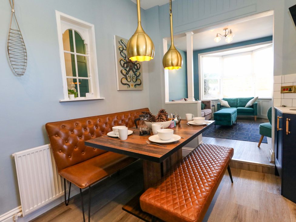 A dining room with a table and benches at The Old Post Office in Weymouth