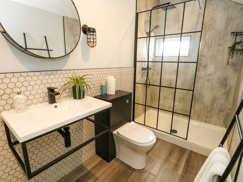 A bathroom featuring a sink, mirror, toilet, and shower at The Old Post Office in Weymouth