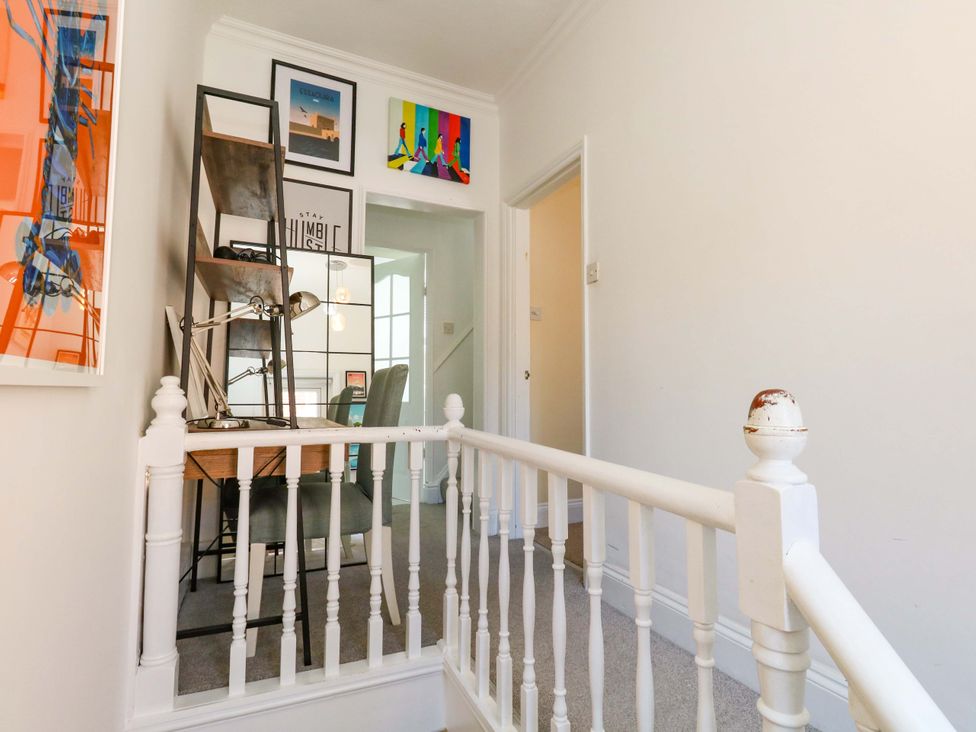 A hallway with a staircase and desk at The Old Post Office Weymouth