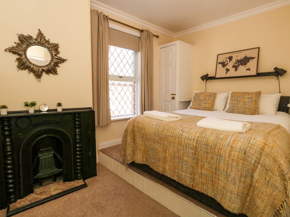 A bedroom with a bed and mirror at The Old Post Office Weymouth