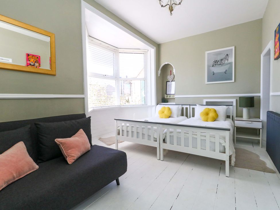 A bedroom with two beds and a sofa at The Old Post Office in Weymouth