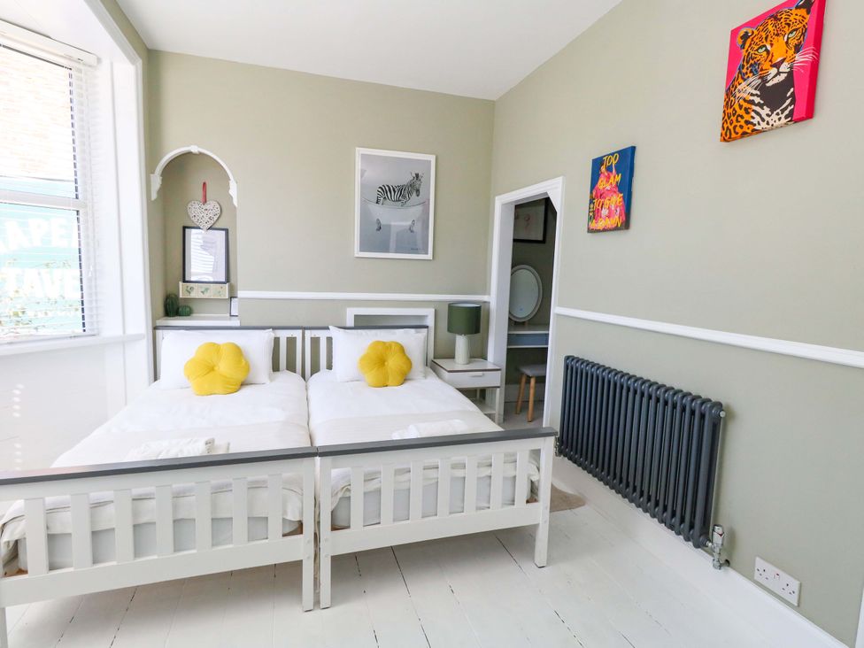A bedroom with beds and a radiator at The Old Post Office in Weymouth