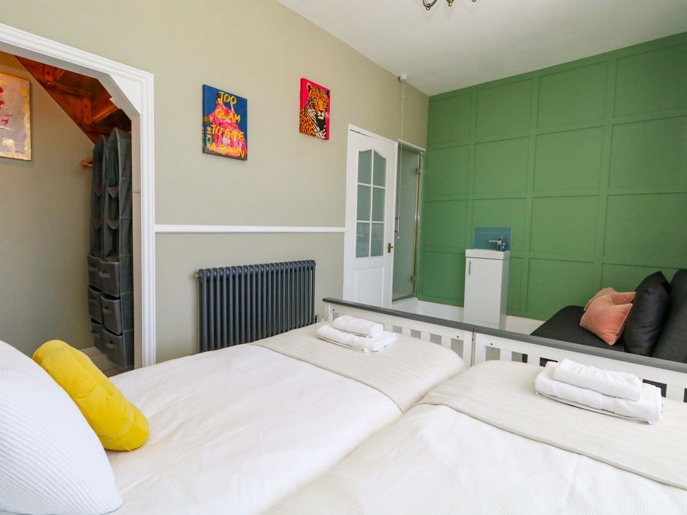 A bedroom with two beds and a sofa at The Old Post Office in Weymouth