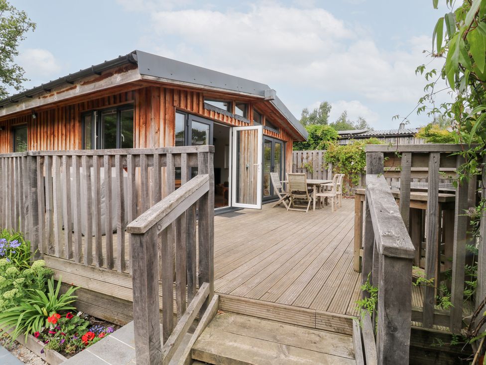 An outdoor area with decking and wooden furniture at Gloccamaura in Bovey Tracey