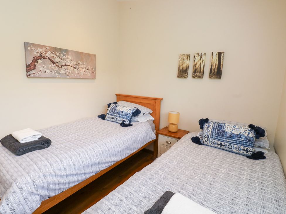A bedroom with two beds and wall art at Gloccamaura in Bovey Tracey