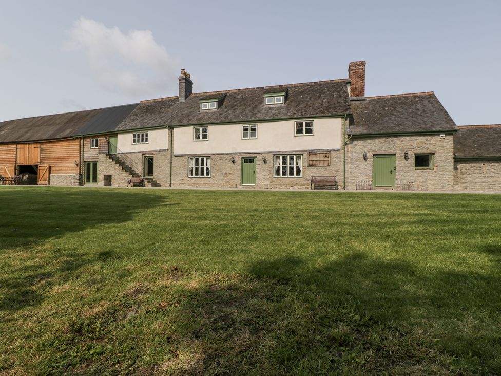 A farmhouse with a barn and grass at Evenjobb Court Farmhouse in Evenjobb near Presteigne