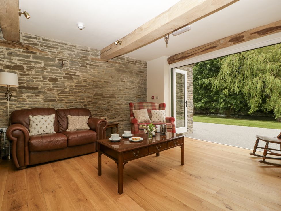 A living room with a sofa and armchair at Evenjobb Court Farmhouse near Presteigne
