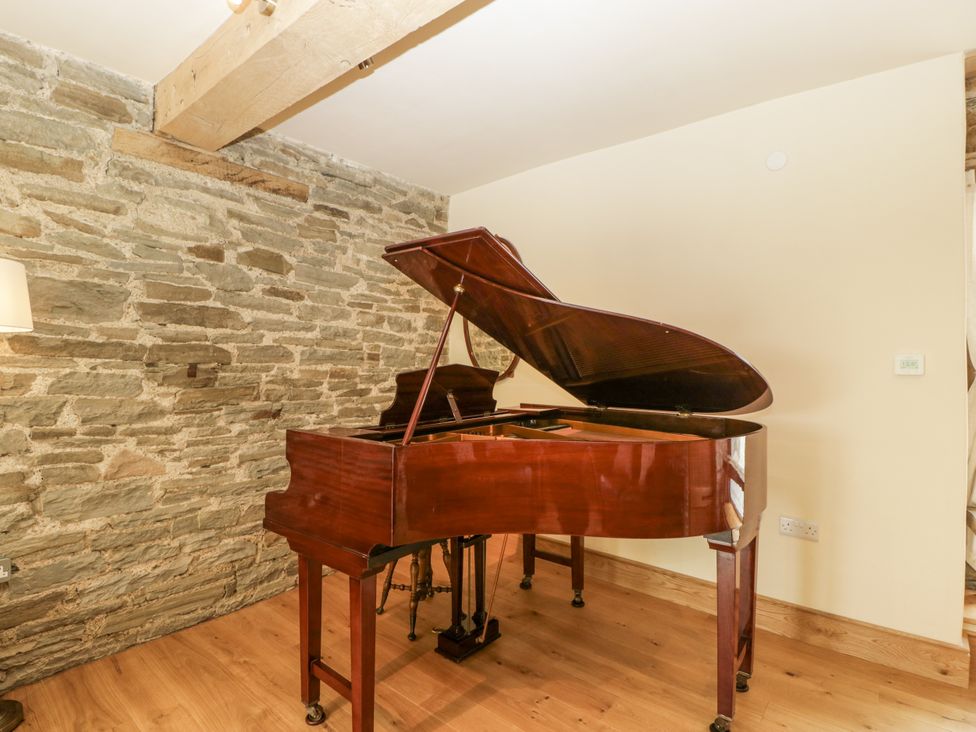 A piano in a music room at Evenjobb Court Farmhouse Evenjobb near Presteigne