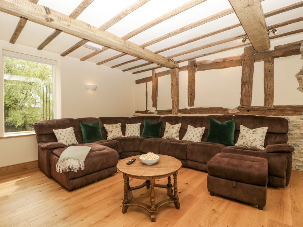 A living room with a sofa and coffee table at Evenjobb Court Farmhouse, Evenjobb near Presteigne