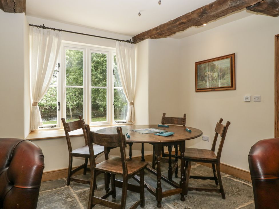A dining room with a round table and chairs at Evenjobb Court Farmhouse in Evenjobb near Presteigne