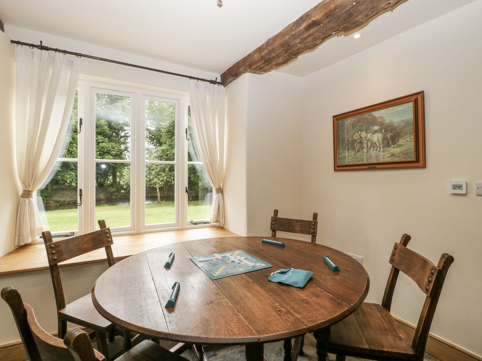 A dining room with a round table and chairs at Evenjobb Court Farmhouse Evenjobb near Presteigne