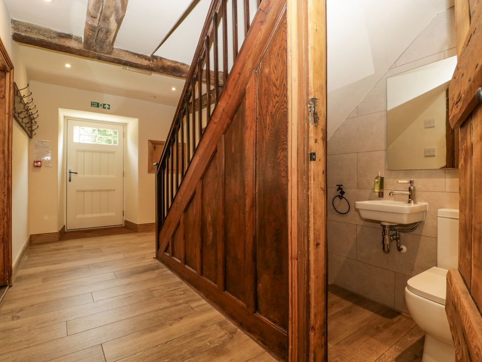 A hallway with a staircase and a hand basin at Evenjobb Court Farmhouse Evenjobb near Presteigne