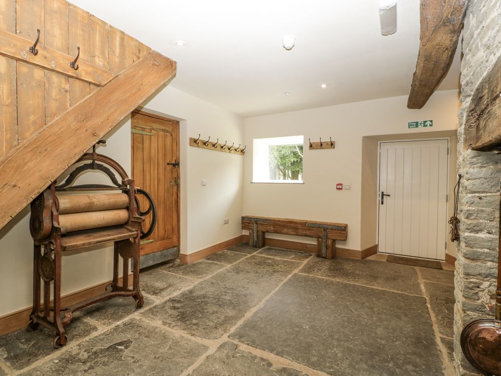 An entrance hall with a bench and a rolltop table at Evenjobb Court Farmhouse in Evenjobb near Presteigne