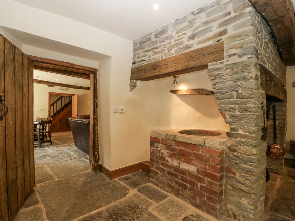 A kitchen with a brick feature and stone wall at Evenjobb Court Farmhouse in Evenjobb near Presteigne