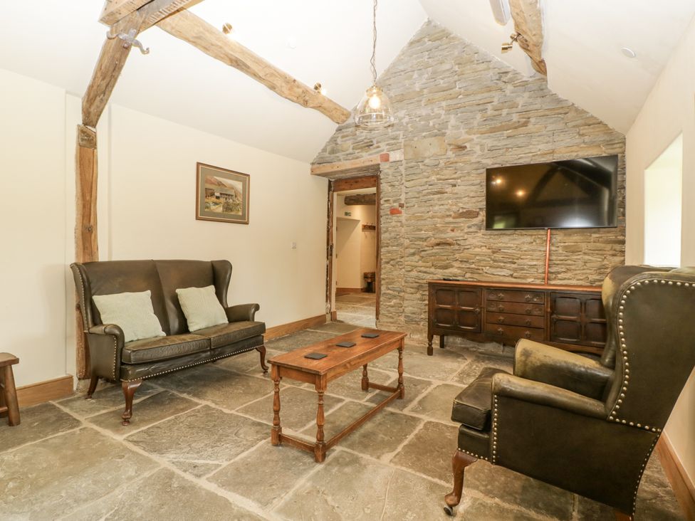 A living room with a sofa and armchair at Evenjobb Court Farmhouse near Presteigne