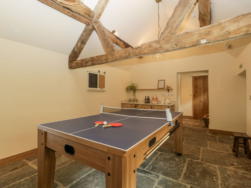 A recreation room with a ping pong table and bar counter at Evenjobb Court Farmhouse Evenjobb near Presteigne