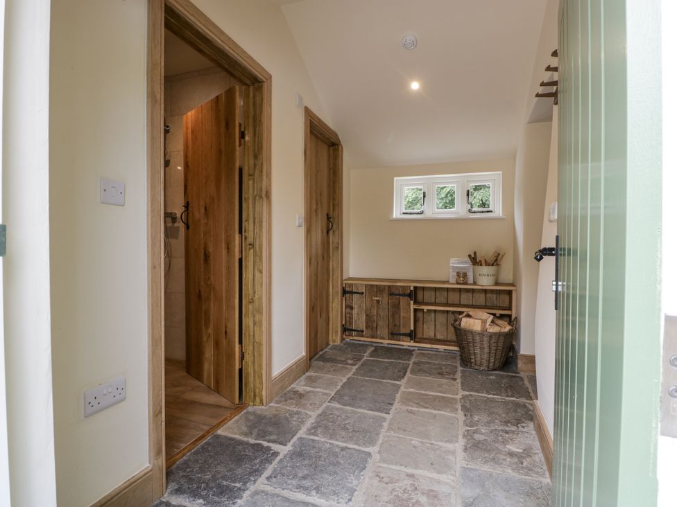 A hallway with storage unit and windows at Evenjobb Court Farmhouse Evenjobb near Presteigne