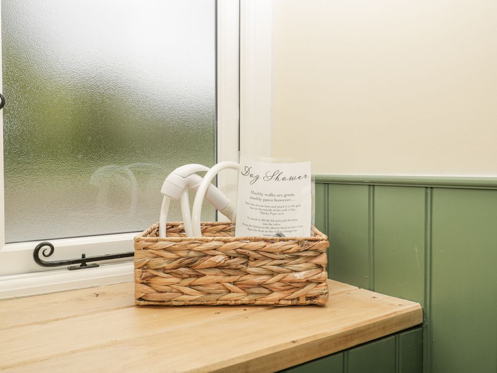 A basket with dog shower sign on a table near a window at Evenjobb Court Farmhouse near Presteigne