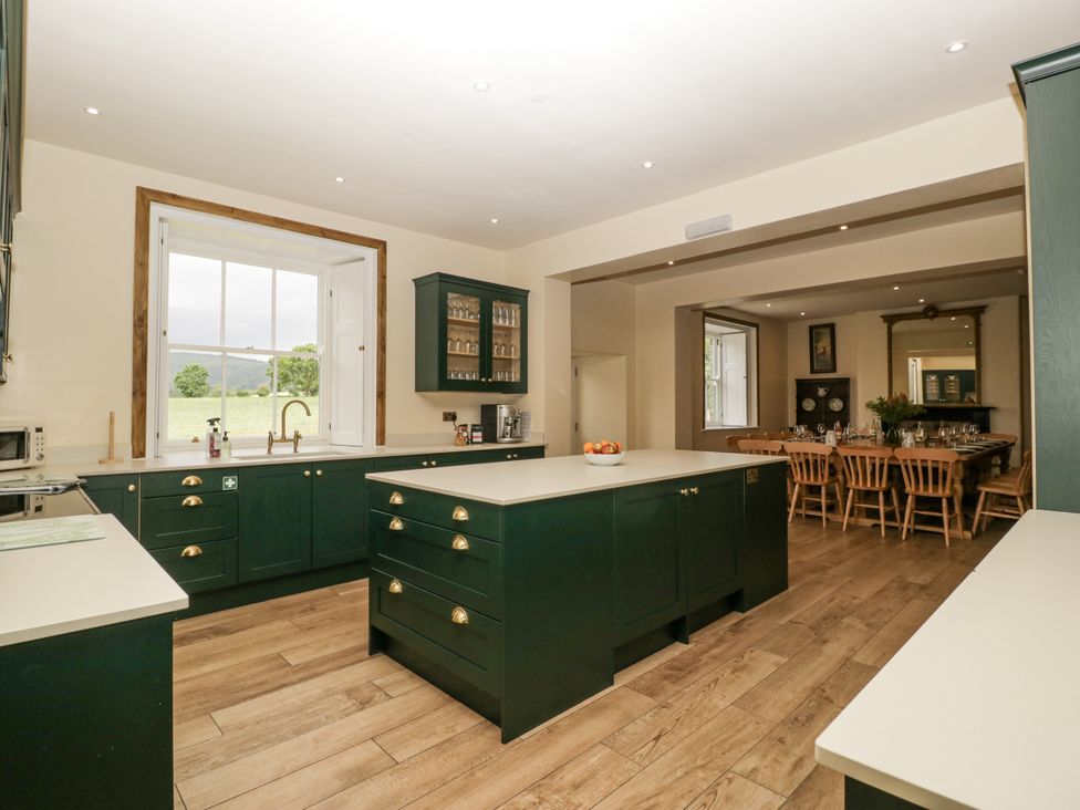 A kitchen with an island and dining area at Evenjobb Court Farmhouse Evenjobb near Presteigne