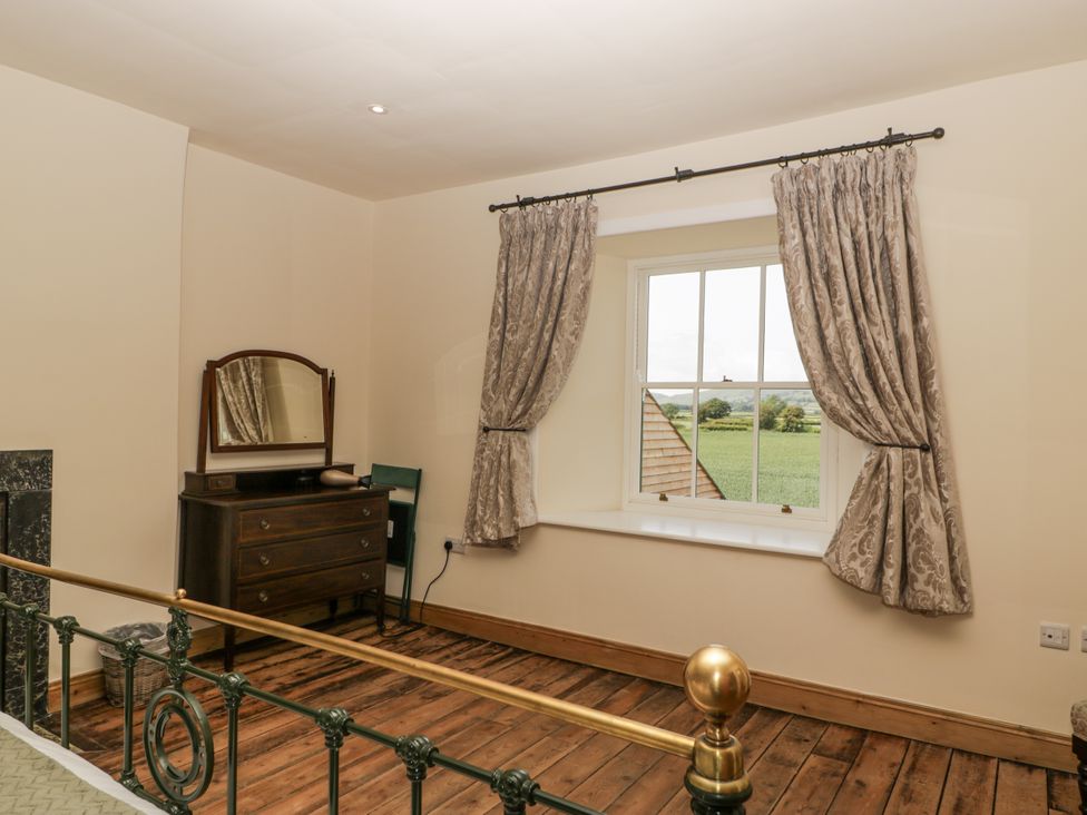 A bedroom with a window and a chest of drawers at Evenjobb Court Farmhouse near Presteigne