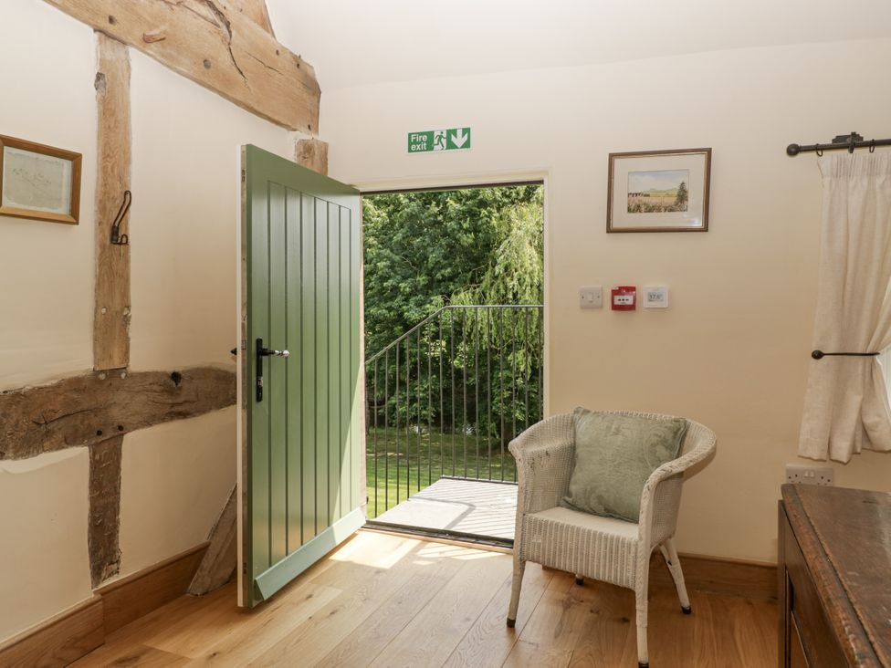 A room with a green door and a chair at Evenjobb Court Farmhouse in Evenjobb near Presteigne