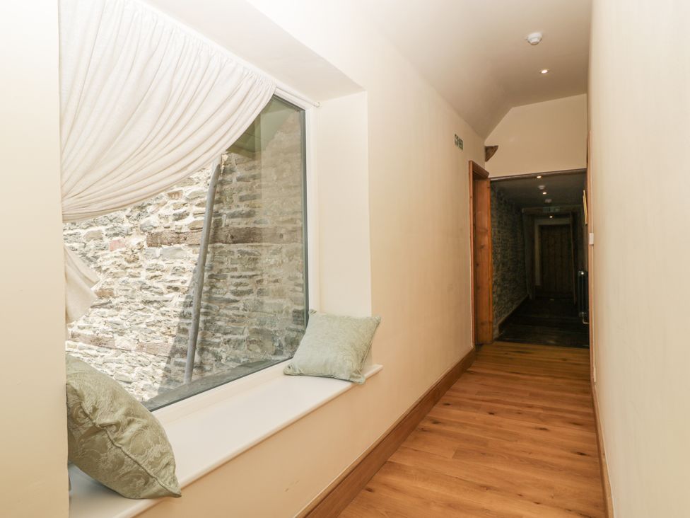 A hallway with a window and cushions at Evenjobb Court Farmhouse near Presteigne