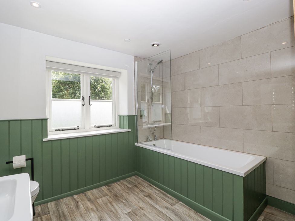 A bathroom with a bathtub and shower at Evenjobb Court Farmhouse near Presteigne