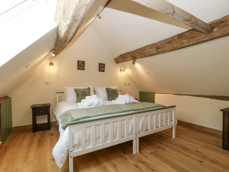 A bedroom with a bed and nightstand at Evenjobb Court Farmhouse near Presteigne
