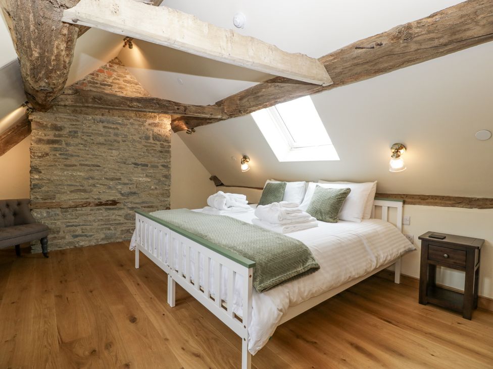 A bedroom with a bed and nightstand at Evenjobb Court Farmhouse near Presteigne