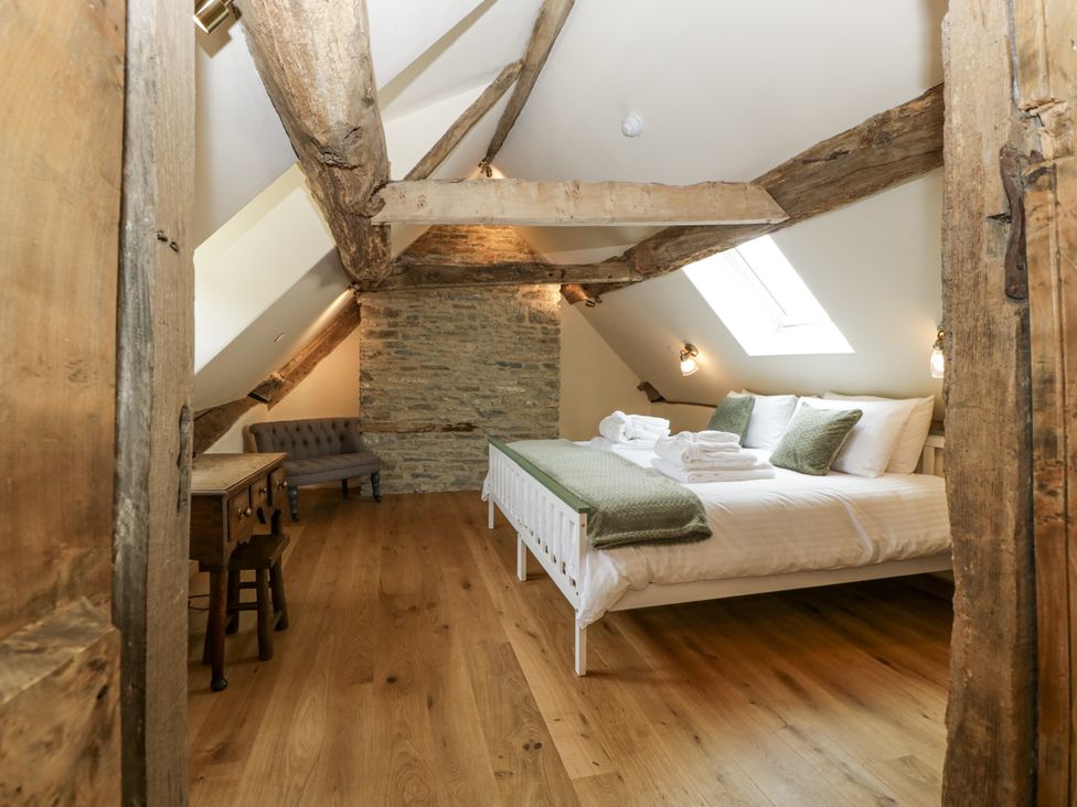 A bedroom with a bed, towels, and a desk at Evenjobb Court Farmhouse Evenjobb near Presteigne