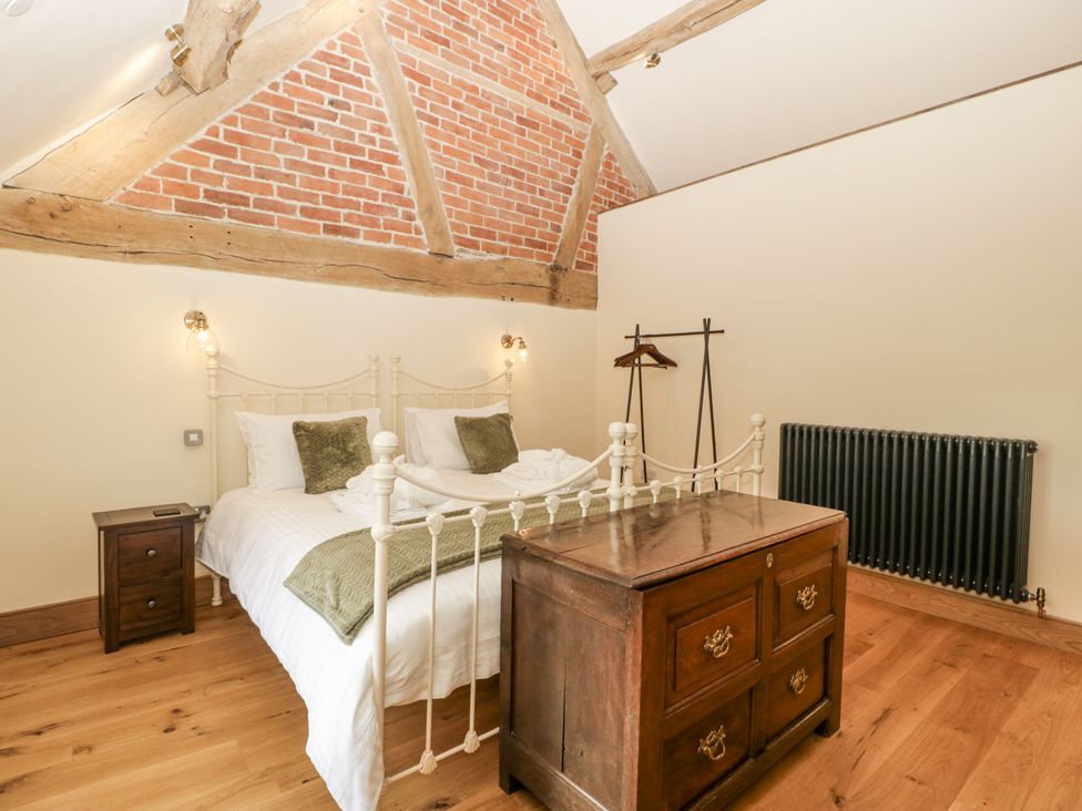 A bedroom with a bed and wooden furniture at Evenjobb Court Farmhouse near Presteigne