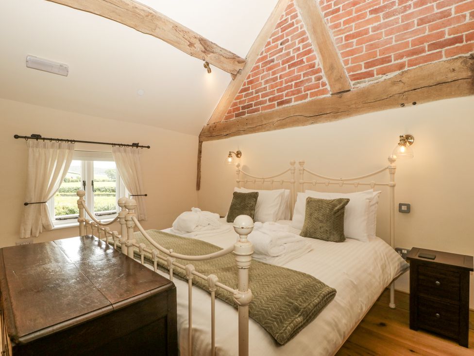 A bedroom with a bed and a window at Evenjobb Court Farmhouse in Evenjobb near Presteigne