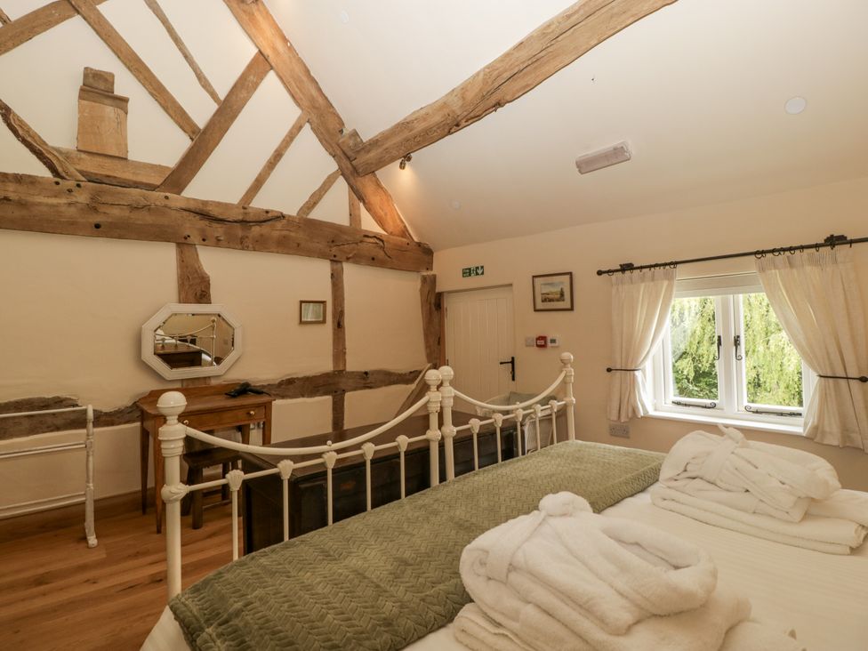 A bedroom with two beds and a mirror at Evenjobb Court Farmhouse in Evenjobb near Presteigne